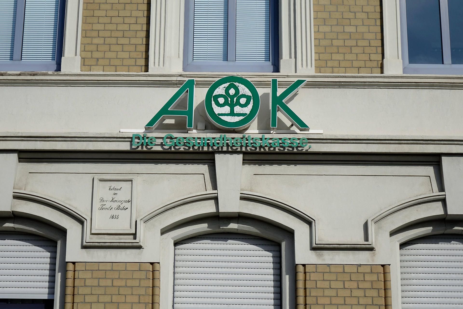Schriftzug der Krankenversicherung AOK über einer Agentur in Stassfurt.