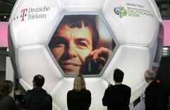 Vor einem überdimensionalen Fußball stehen Mitarbeiter des Telekom-Standes kurz vor Beginn der Computermesse CeBIT in Hannover (Archivfoto vom 08.03.2006). (Foto: dpa)