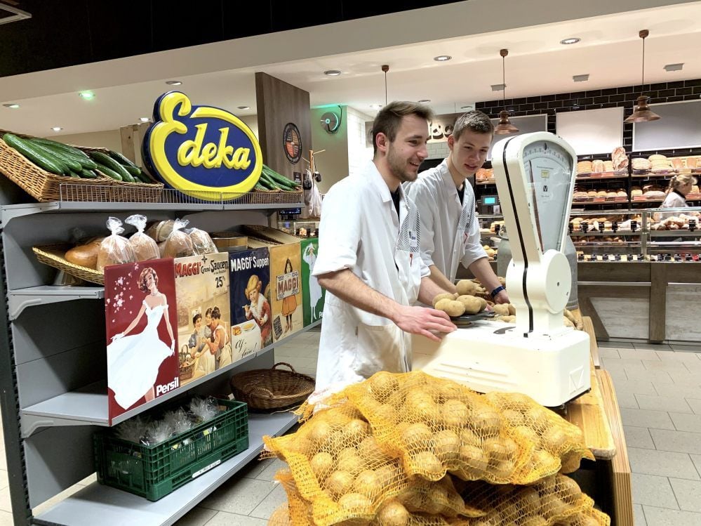 Benedikt Wendt (vorne) und Moritz Lehmann bereiteten den Marktstand im Eingangsbereich vor. Hier sollen die Kunden einkaufen können, wie es vor 100 Jahren üblich war. Bis einschließlich Samstag führen die Nachwuchskräfte des Edeka-Höhne das Azubi-Nachwuchsprojekt durch.