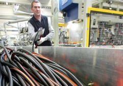 Klaus Buro, Mitarbeiter der Eldisy GmbH in Gardelegen, bestückt einen Fertigungsautomaten mit Gummidichtungen. (Foto: dpa)
