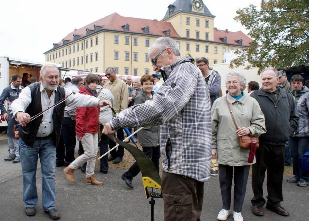 Georg Stibale aus Zeitz probiert zum Vergnügen anderer Gäste, mit dem Geigenbogen einem Sägeblatt Töne zu entlocken - und schafft es auch.