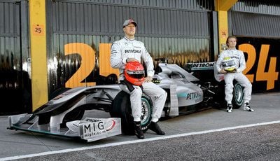 Michael Schumacher (l.) und Nico Rosberg (r.) sitzen auf der Rennstrecke in Valencia (Spanien) auf den Reifen des neuen Mercedes Rennwagen MGP W01. (FOTO: DPA)