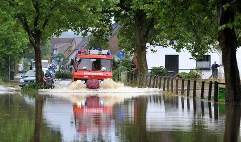 Ein Feuerwehrfahrzeug fährt in Westerhausen (Landkreis Melle) durch eine überschwemmte Straße. (FOTO: DPA)