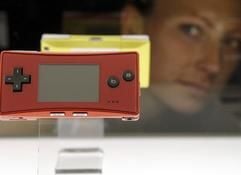 Eine junge Frau betrachtet am Donnerstag (18. August 2005) auf der größten europäischen Computerspiel-Messe «Games Convention» in Leipzig zwei tragbare Spiele-Konsolen «Game Boy Micro» (80 Gramm schwer) von Nintendo. (Foto: dpa)
