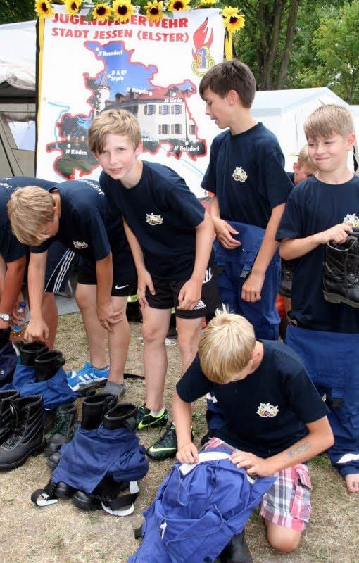 Spezielle Kleidung, die den Anforderungen der Feuerwehr gerecht wird, einschließlich fester Stiefel, legen auch die Nachwuchslösch-„Männer“ an.