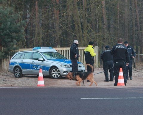 Ein Polizist und ein Fährtenhund suchen am Freitag nach dem Fund von drei Leichen auf dem Gelände des Schießstandes Hüttermühle in Genthin (Kreis Jerichower Land) Spuren. (FOTO: DPA)