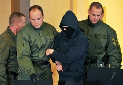 Polizisten und der vermummte Angeklagte Alex W. (28) im Prozesses um den gewaltsamen Tod der Ägypterin Marwa El-Sherbini. (FOTO: DPA)