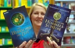 Buchhändlerin Andrea Fritzsche zeigt in Magdeburg die Bücher «Der Herrscher der Zeit» (Heyne-Verlag) und «Die Tochter der Himmelsscheibe» (Piper-Verlag). (Foto: dpa)