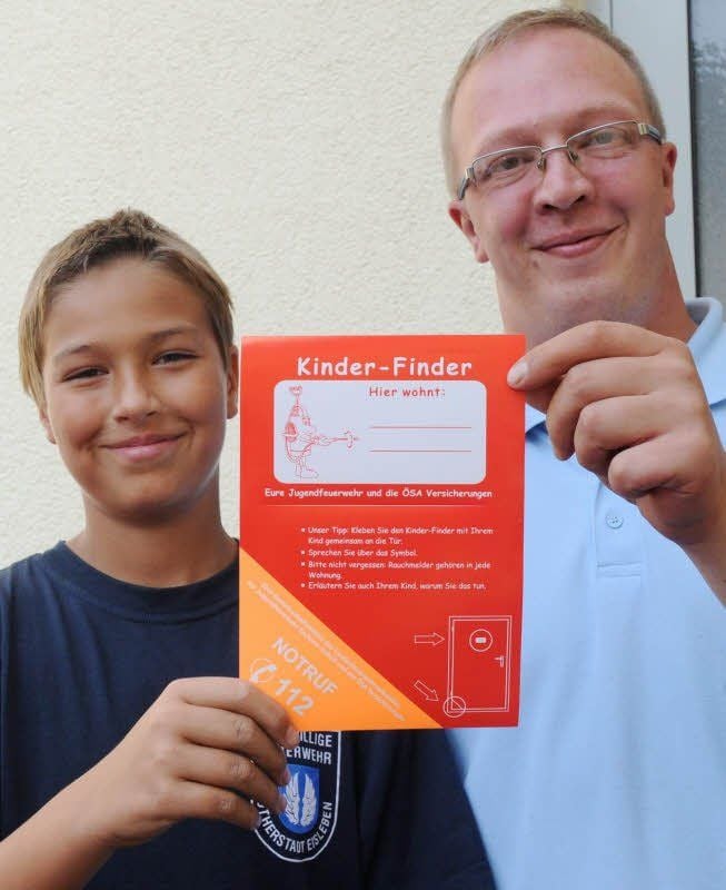 Danny Suck (links) und Jugendwart David Schmidt von der Eisleber Feuerwehr mit dem Aufkleber.