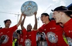 Die Münchner Spieler Michael Ballack, Ze Roberto, Lucio und Bastian Schweinsteiger (v.l.) jubeln nach dem 4:0-Sieg des FC Bayern in Kaiserslautern mit einem Imitat der Meisterschale. (Foto: dpa)