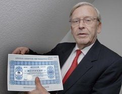 Der Vorstand der Kötitzer Ledertuch- und Wachstuch-Werke AG, Werner Harder, zeigt in Norderfriedrichskoog (Kreis Nordfriesland) die mit 11 000 Euro teuerste Aktie Deutschlands. (Foto: dpa)