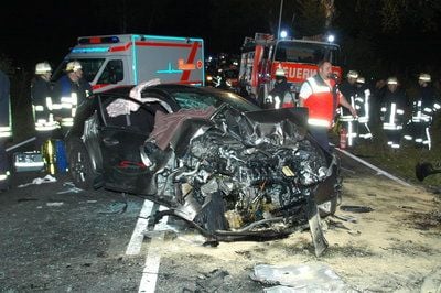 Rettungskräfte stehen nahe der Ortschaft Insel bei Stendal in Sachsen-Anhalt neben einem der beiden Auto-Wracks an der Stelle eines schweren Verkehrsunfalls, bei dem fünf Menschen getötet und zwei schwer verletzt worden sind. (Foto: dpa)