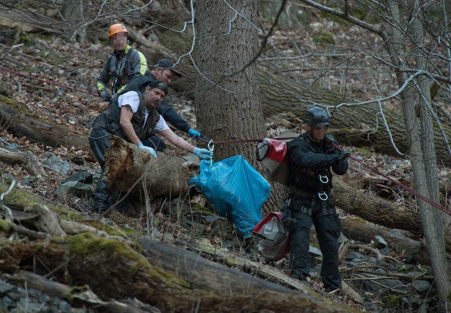 Zwei SEK-Männer (mit Helm) sowie Kriminaltechniker Andreas Lehmann und dessen Kollege bringen am Donnerstag den Sack mit Leichenteilen vom Hang nach unten auf den Wanderweg.