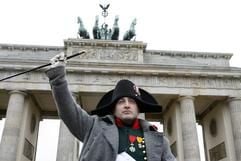 Mit der Reitpeitsche winkt der als Napoleon verkleidetete amerikanische Schauspieler Mark Schneider, nachdem er durch das Brandenburger Tor in Berlin geritten war. (Foto: dpa)