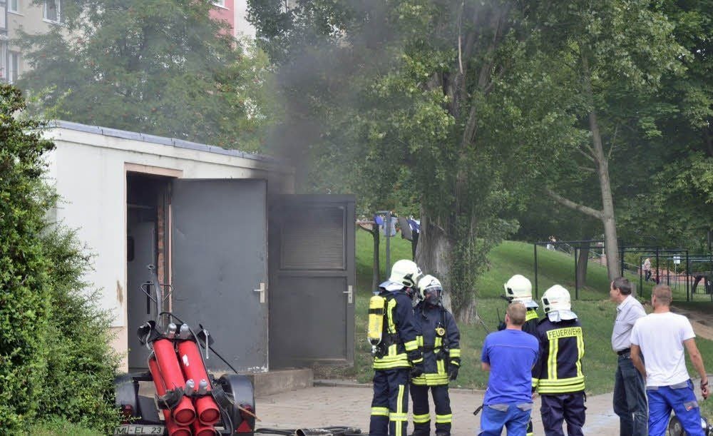 Mitglieder der Feuerwehr Eisleben und Mitarbeiter der Eisleber Stadtwerke an der havarierten Trafostation.