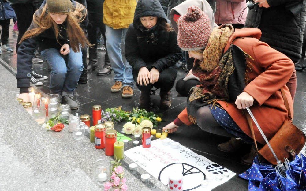 Mit Blumen und Kerzen auf der Treppe vor dem Ratshof gedachten die Hallenser der Opfer von Paris.