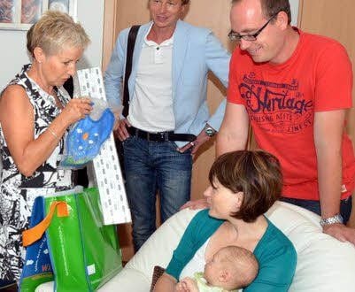 Christine Hepner (l.) übergibt das Paket an die junge Familie.