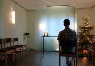 Ein Mann sitzt in einem Andachtsraum in einem Hospiz. (Foto: dpa)