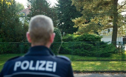 Ein Polizist steht vor dem Anwesen einer Unternehmerfamilie im brandenburgischen Bad Saarow (Oder-Spree). (FOTO: DPA)