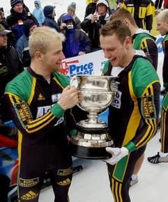 Fahrer Andre Lange (li.) und Carsten Embach (re) halten nach dem Sieg ihre Trophäe. (Foto: dpa)
