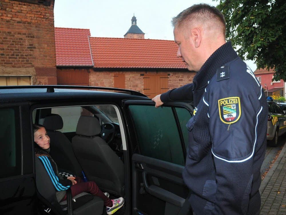 Polizeioberkommissar Stefan Meyer ist zufrieden: Die neunjährige Lina Bornkessel sitzt auf einem Kindersitz und ist richtig angeschnallt.