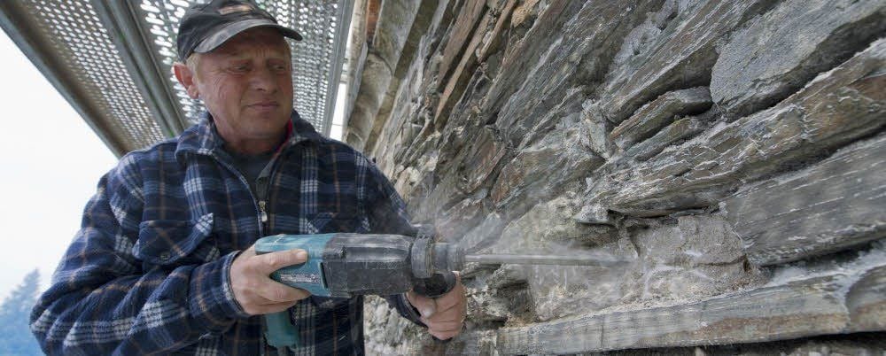 Sanierungsarbeiten am Kirchturm in Güntersberge: Bernd Försterling entfernt mit einem Bohrmeißel die weichen Fugen.