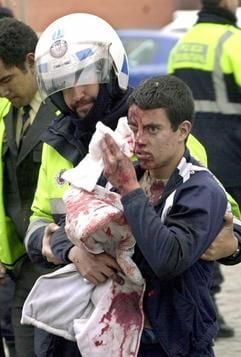 Ein spanischer Polizist hilft einem blutüberströmten Jungen. (Foto: dpa)