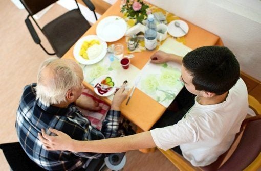 Ein Helfer kümmert sich um einen älteren Mann.