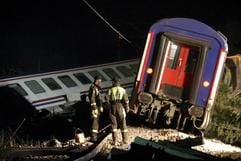 Zwei Männer eines Rettungsdienstes stehen unweit der Stadt Sakarya in der Türkei vor den Wracks von zwei ineinander verkeilten Wagen des verunglückten Zuges. (Foto: dpa)