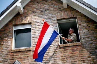 Der Niederländer Joop Peren hängt an seinem Haus in Kranenburg (Kreis Kleve) die niederländische Landesfahne auf. (FOTO: DPA)
