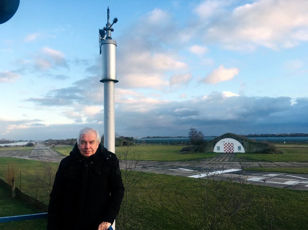 Jürgen Paschmionka auf dem Tower, im Hintergrund ein Shelter und die Landebahn des Flugplatzes.
