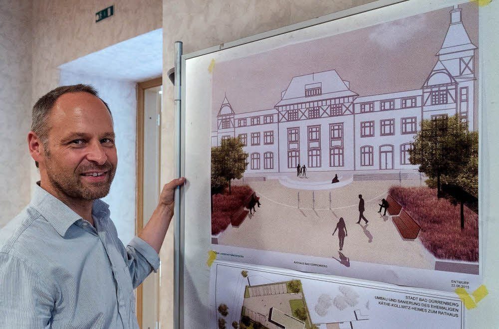 Christian Weber vom Architekturbüro Eßmann, Gärtner, Nieper vor dem Plan vom Rathaus (Vorderansicht Haupteingang).