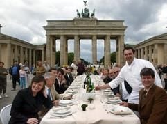 «Probetafeln» vor dem Brandenburger Tor - Küchenchef Harald Wohlfahrt (2.v.r) hält am Donnerstag (24.06.2004) vor dem Brandenburger Tor in Berlin die Suppenkelle in der Hand und posiert zusammen mit Test-Gästen an einer gedeckten Tafel für die Medien. Am 03. Juli 2004 wird zu Ehren des neuen Bundespräsidenten Horst Köhler eine «Tafel der Demokratie» mit 1200 geladenen Gästen unter freiem Himmel vor dem Wahrzeichen der Hauptstadt eingedeckt. (Foto: dpa)