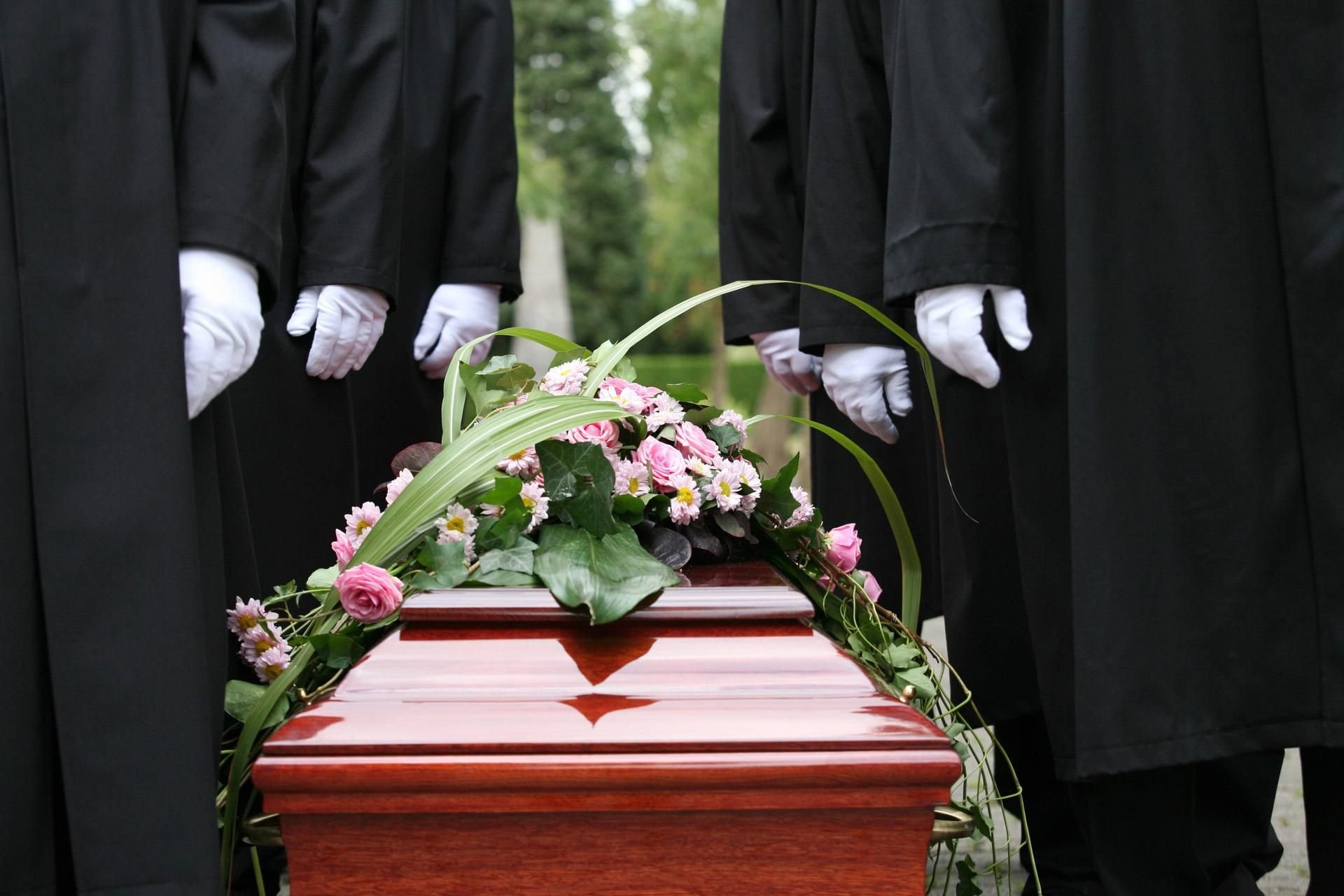 Träger stehen auf einem Friedhof neben einem Sarg. Sachsen-Anhalts Regierung will die Öffnung per Bestattungsgesetz für Traditionen, die im Islam und Judentum verbreitet sind.