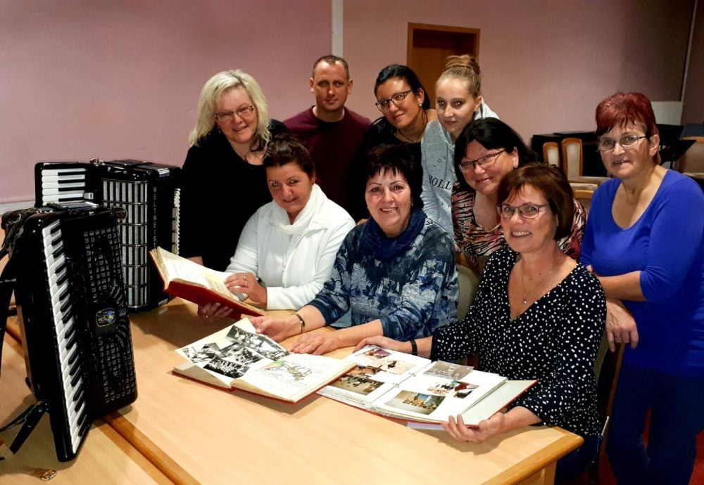 Mitglieder blättern in Erinnerungen: Anke Bittner-Pedroso, Maik Schuhmann, Christel Ermisch, Anna Manthey, Ursula Bienhold, Veronika Sappok (stehend v.li.) sowie Martina Hillmer, Andrea Wölfer und Heike Vogel (sitzend v.li.)