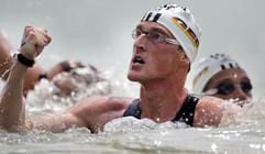 Der deutsche Schwimmer Thomas Lurz (M) jubelt am Mittwoch in Balatonalmàdi bei Budapest über seinen Gewinn bei der Schwimm-Europameisterschaft über die 10 Kilometer Langstrecke (26.07.2006). Rechts sein Mannschaftskollege Christian Hein, der dritter wurde. (Foto: dpa)