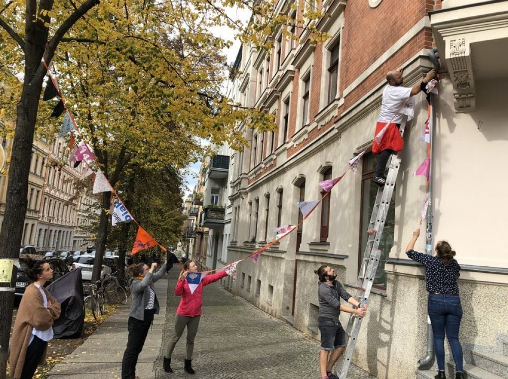 Bewohner der Humboldtstraße hängen bunte Wimpel auf.