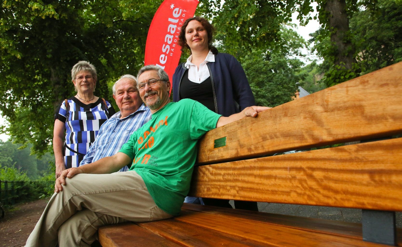 Auf der Bank am Riveufer mit Namen Maiumpanorama sitzen Mitglieder des Vereins zur Probe: Christine Müller, Wolfgang Kupke (Vorsitzender), Manfred Lindner und Anne Kupke.
