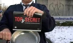 Vor der Zentrale des Bundesnachrichtendienstes in Pullach bei München zeigt ein Mitarbeiter das erste Kochbuch der Behörde. Unter dem Titel «Top(f) Secret» ist in zwei Dutzend Rezepte aus den verschiedensten Einsatzgebieten der Geheimdienstler beschrieben, was dort so in die Pfanne gehauen wird. (Foto: dpa)