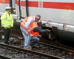 Bahnmitarbeiter stehen neben einem entgleisten ICE am Hauptbahnhof in Köln. Nach dem ICE-Unfall auf der Kölner Rheinbrücke hat sich die Staatsanwaltschaft in die Untersuchungen eingeschaltet. (Foto: dpa)