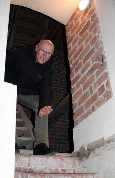 Pfarrer Hans-Jörg Heinze, seit 2003 in Axien, zeigt den ursprünglichen, erhöht liegenden Eingang zum Turm.