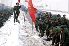 Einer gibt die Kommandos, und über allen weht die rote Fahne: Soldaten beim Einsatz gegen den Schnee in Nanjing im Osten Chinas. (Foto: dpa)