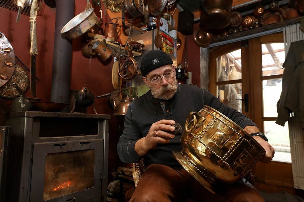 Herbert Bauer poliert ein Gefäß für Bowle auf Hochglanz. Es stammt aus der Jugendstil-Zeit.