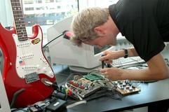 Junger Tüftler am Werk: Christopher Adams aus Hamburg hat ein Verfahren entwickelt, mit dem sich Gitarren fast von selbst stimmen. (Foto: dpa)