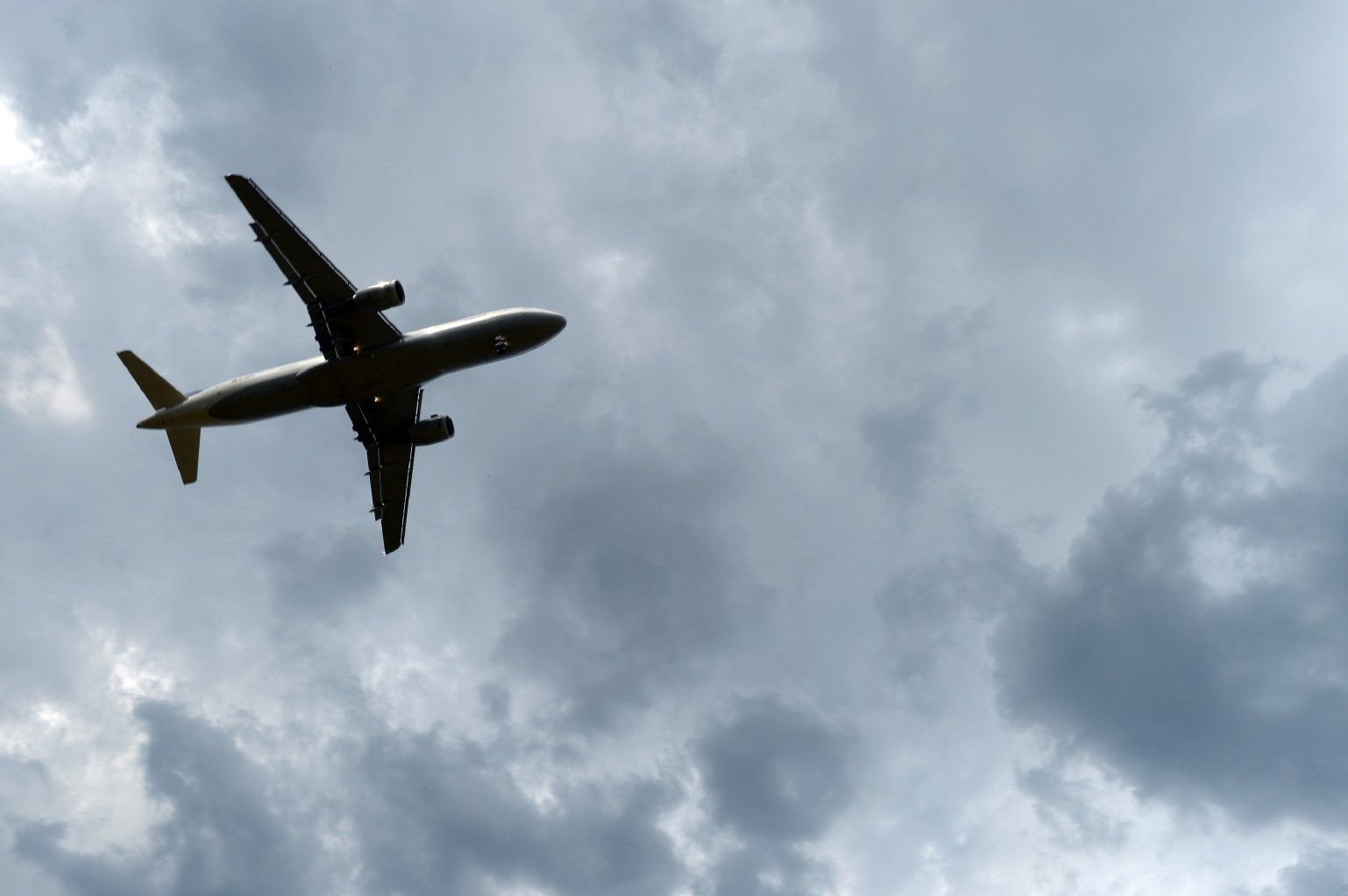 Gewitterwolken türmen sich am 23.07.2013 in Köln (Nordrhein-Westfalen) über einem landenden Flugzeug auf.