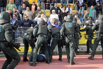 Beim Ostderby stürmen kurz vor Spielende Jenauer Anhänger in den Innenraum und müssen von Polizisten aufgehalten werden. Wegen der Ausschreitungen mußte das Spiel kurzzeitig unterbrochen werden. (Foto: dpa)