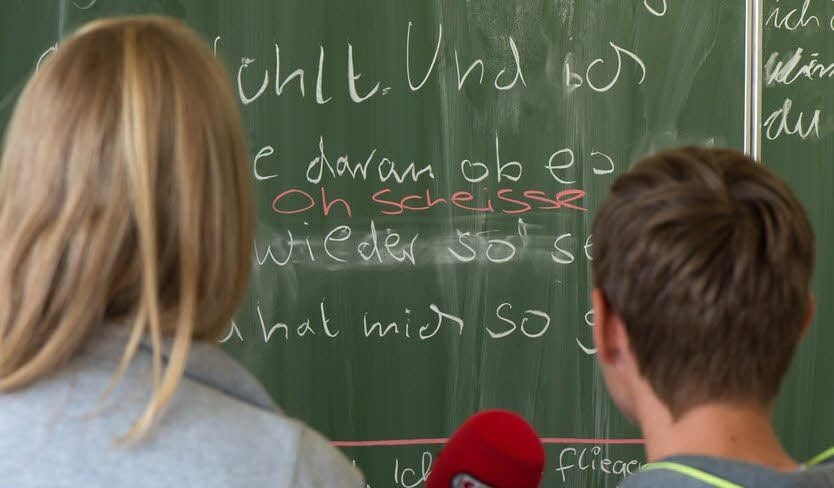 Bei der Aufnahme fürs Radio versprochen und geflucht? Was soll’s! Warren Green fügte den „Fluch“ - sehr zum Gaudi für die Klasse - für den nächsten Versuch einfach mit farbiger Kreide in den übersetzten Text ein.