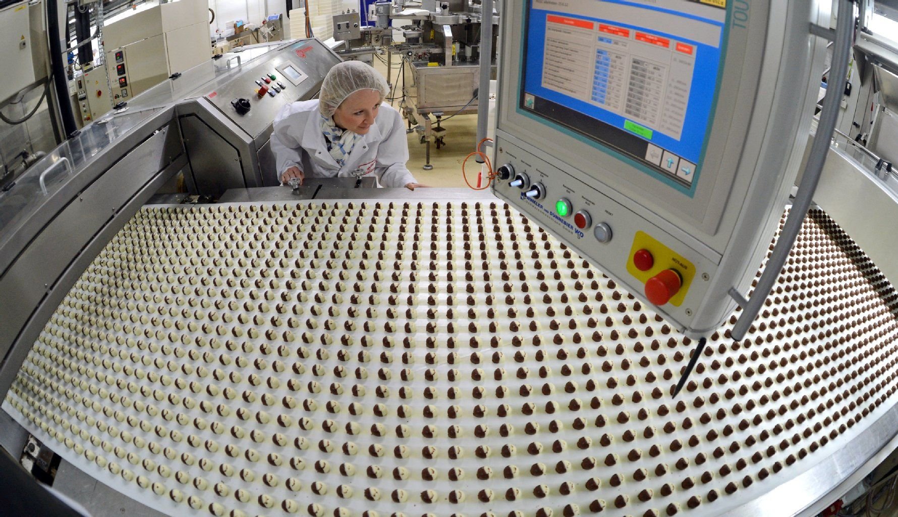 Eine Mitarbeiterin der Halloren Schokoladenfabrik AG überwacht die Produktion von Halloren-Kugeln.