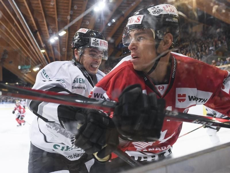 Nürnbergs Oliver Mebus (l) und der Kanadier Adam Cracknell kämpfen um den Puck. Foto: Gian Ehrenzeller/KEYSTONE