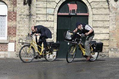 Philippe (Kad Merad l-r) und Antoine (Dany Boon) fahren im Film «Willkommen bei den Sch´tis» gemeinsam in Bergues die Post aus. Der Postbeamte Philippe wird in die nördliche Provinz strafversetzt, wundert sich über die Zischlaute des dortigen Dialekts und versucht aus Liebe zu seiner schönen, aber leider depressiven Frau mit allen Mitteln, eine Versetzung an die sonnige Riviera zu erreichen. (Foto: dpa)